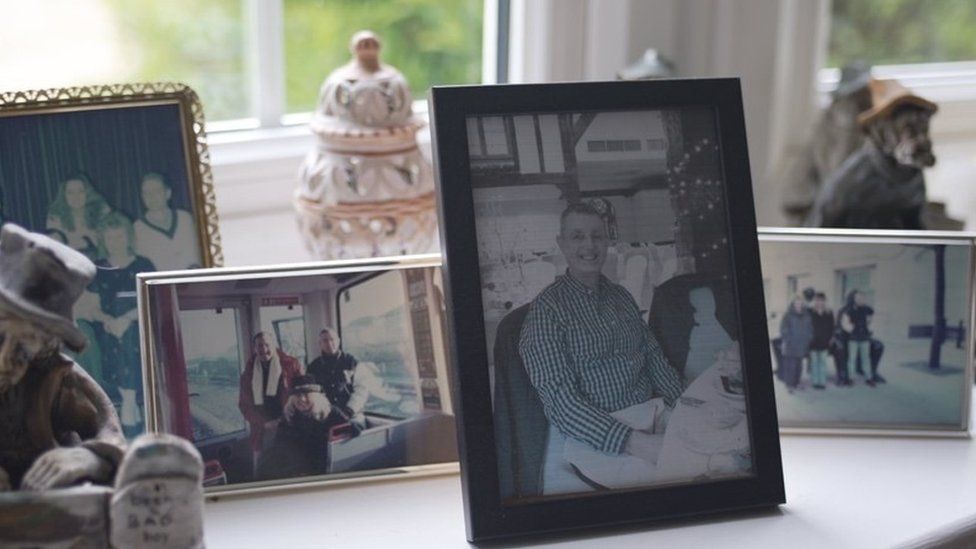 Photos of Paul and Simon stand on a windowsill in Rachel Mason's home.