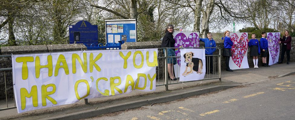 Pupils and teachers from Aldington Primary School pay their respects to Paul O'Grady with picture collages of their drawing of dogs along the route of his funeral in the village of Aldington, Kent ahead of his funeral