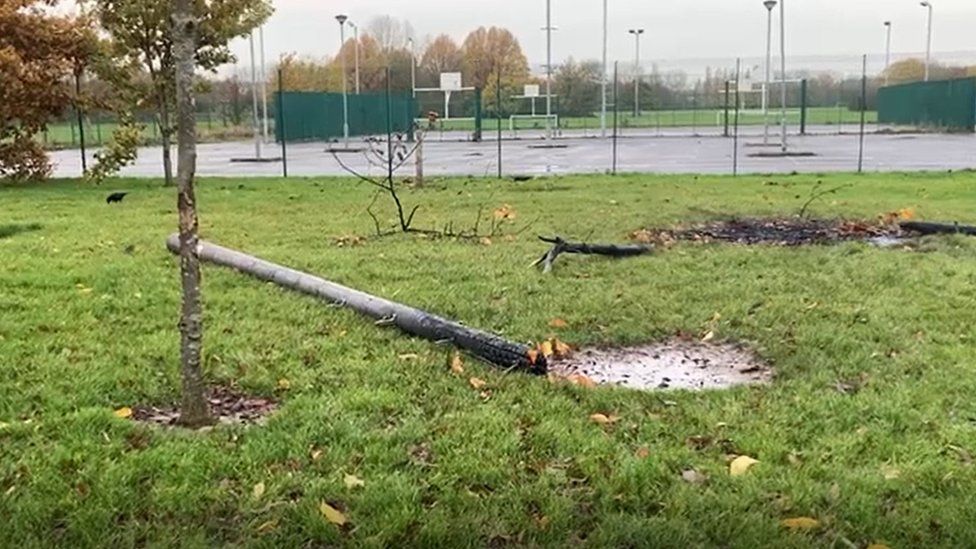 A broadband pole cut down and lying on ground