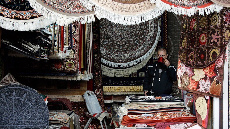 An Iranian shopkeeper at a stand in a market in Tehran, Iran, 5 November 2018