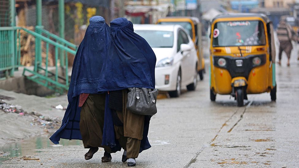 mujeres caminando por una calle con burka