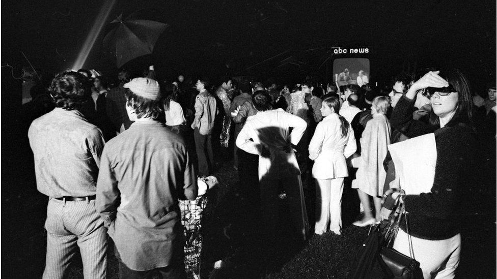 Gente reunida en Central Park, en Nueva York, para ver los reportes del aterrizaje del Apolo 11 en la Luna en una de las tres pantallas gigantes instaladas por las tres principales cadenas estadounidenses.