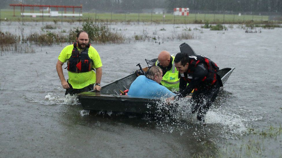 Rescuers with a resident in a boat in North Carolina
