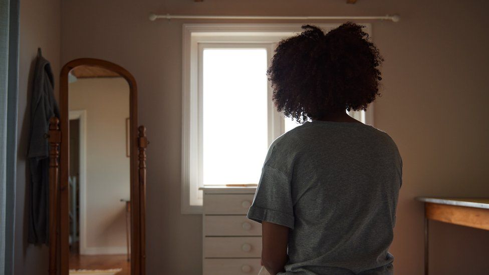 A woman sits on a bed