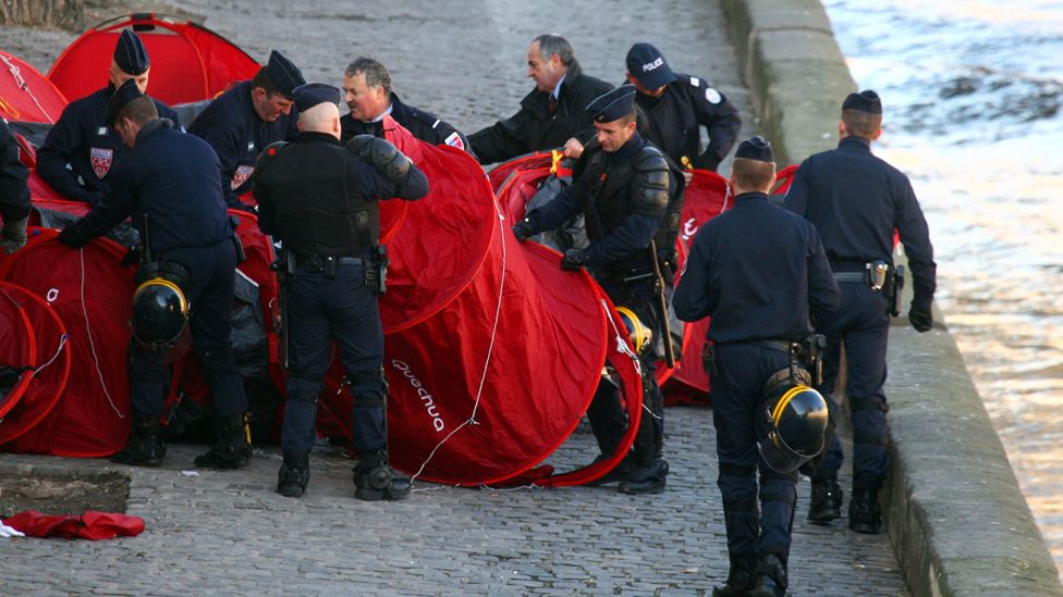 French policemen evacuate some tents set up for homeless people by 'Les Enfants de Don Quichotte' (The Children of Don Quixote) earlier in the morning, 15 December 2007 near Notre Dame of Paris cathedral.