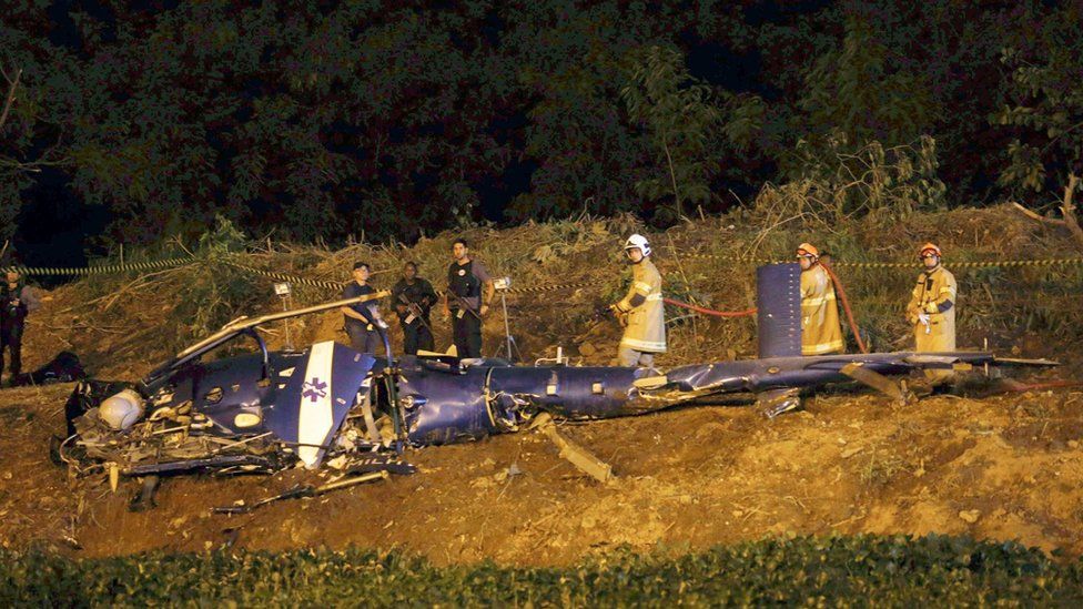 Emergency workers at the scene of a police helicopter crash over the City of God favela in Rio de Janeiro, Brazil, 19 November 2016.