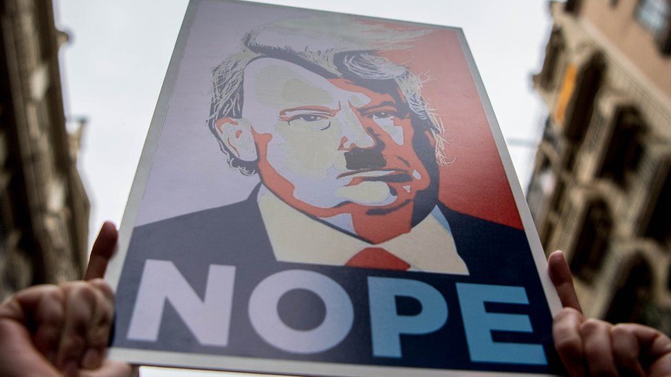 Demonstrators hold posters of Donald Trump as they make their way during the Women's March on January 21, 2017 in Barcelona, Spain.