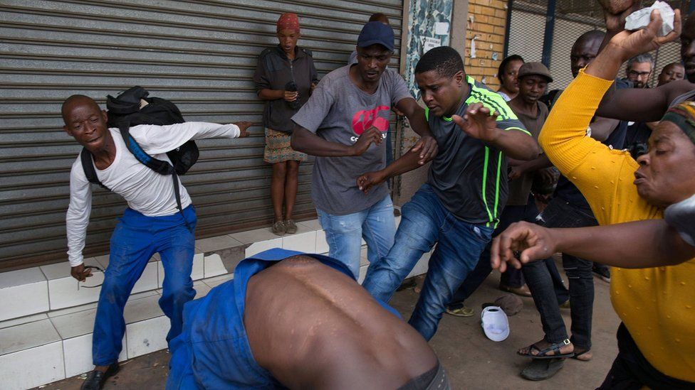 A vigilante mob attacks a Nigerian migrant outside a church in Pretoria, South Africa 18 February