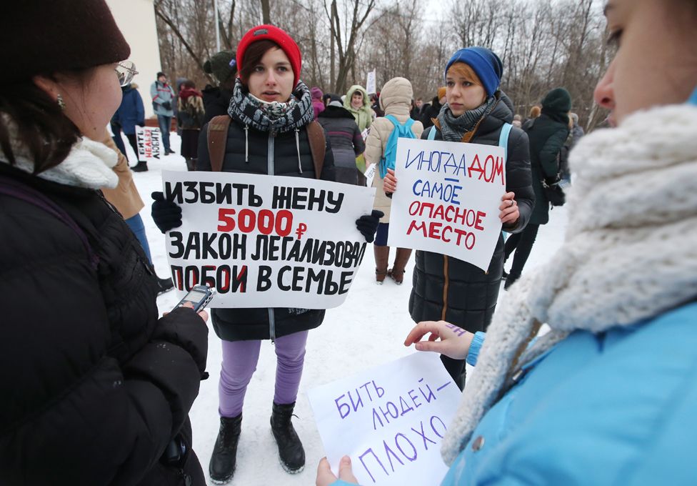 Protesters in a Moscow park - the placard on the left points out that the new fine for wife-beating is 5,000 roubles (£60)