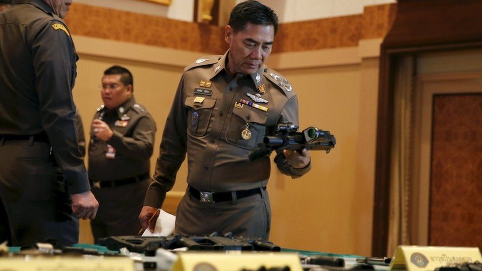 National police chief Chakthip Chaijinda inspecting alleged evidence at Bangkok press conference