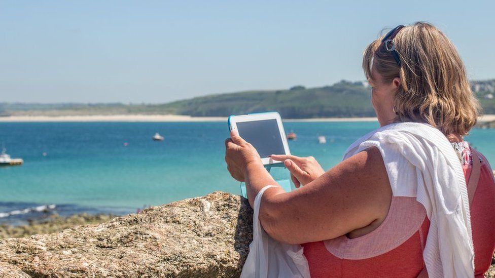 File photo of a woman on a beach with a tablet