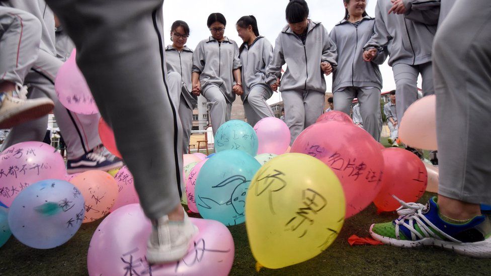 This photo taken on May 24, 2016 shows senior high students trampling balloons to release stress before the college entrance exams at a high school in Handan, north China's Hebei province.