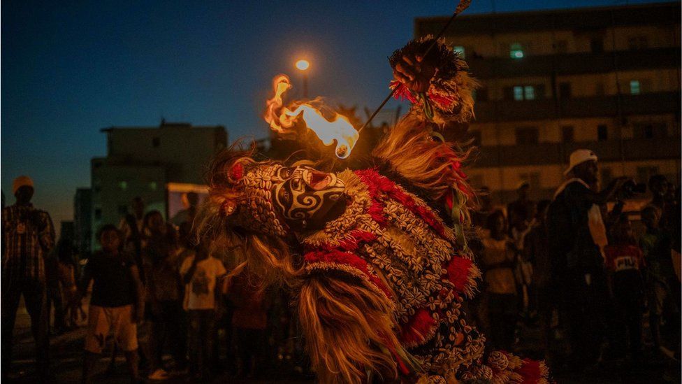 A man dressed as a lion eating fire