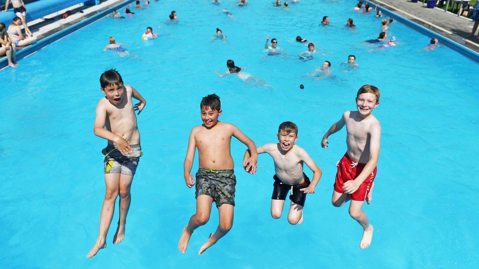 Children play in the water at Hathersage outdoor swimming pool