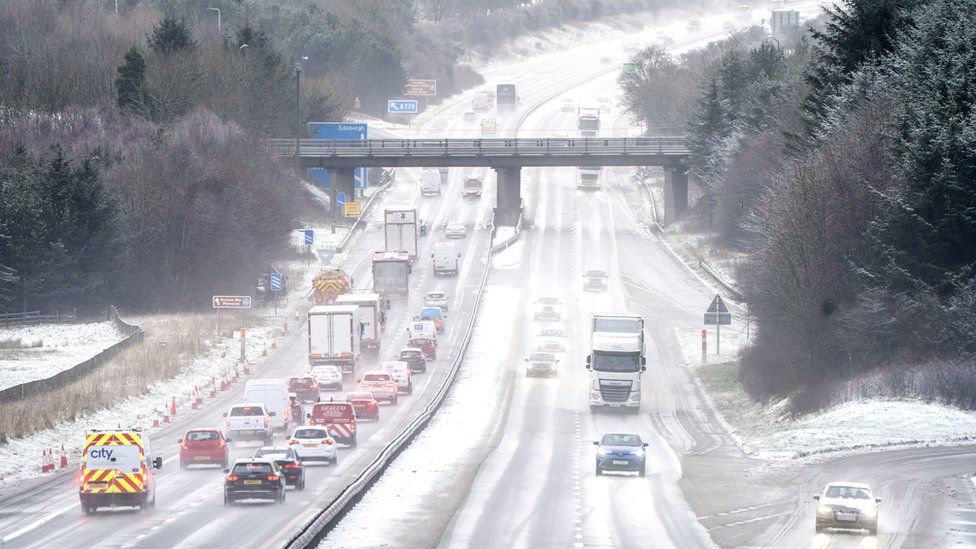 Motorists drive through the sleet and snow along the M8 motorway near Bathgate in West Lothian as Storm Eunice sweeps across the UK