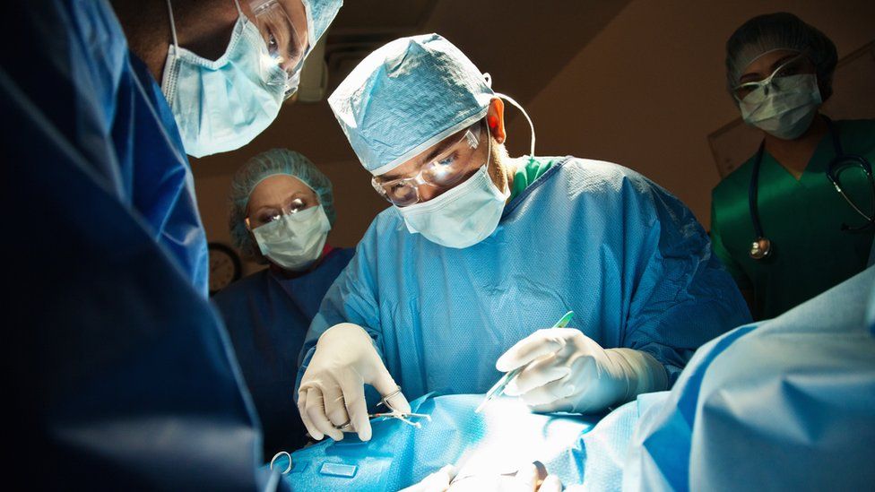 Doctors performing surgery on a pregnant woman