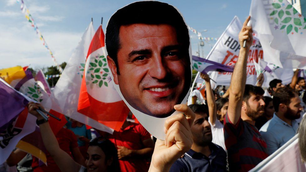 A supporter of Turkey's main pro-Kurdish Peoples' Democratic Party (HDP) holds a mask of their jailed former leader in 2018