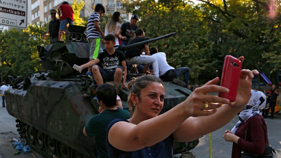 A woman takes a selfie in front a damaged Turkish military APC in Ankara on 16 July, 2016