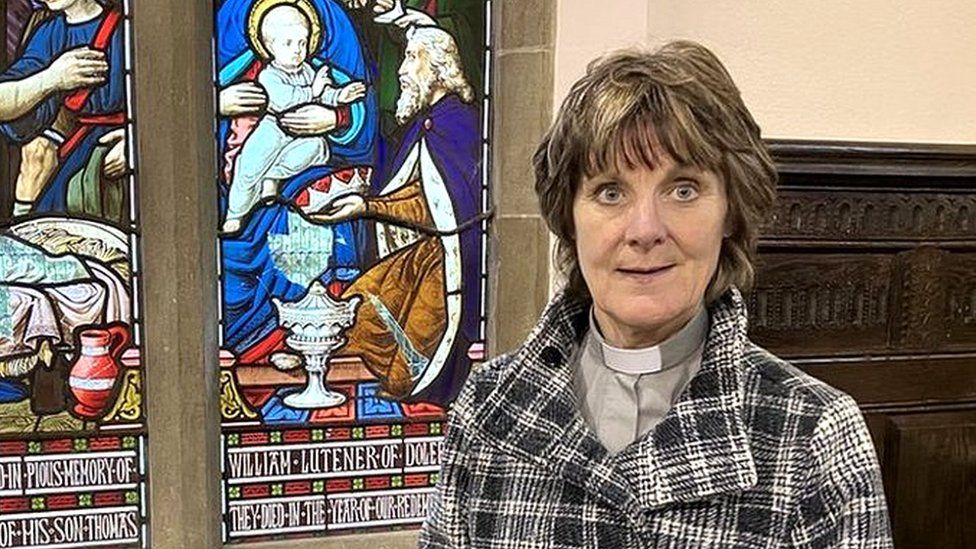 Nia Wyn Morris standing beside the church windows