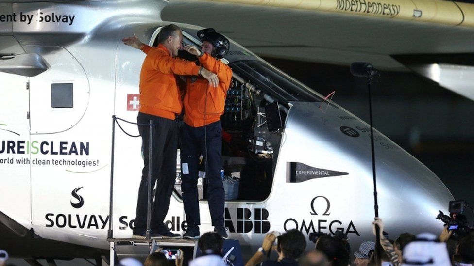 Pilots Andre Borschberg (L) and Bertrand Piccard hug at the end of the Solar Impulse's round-the-world journey