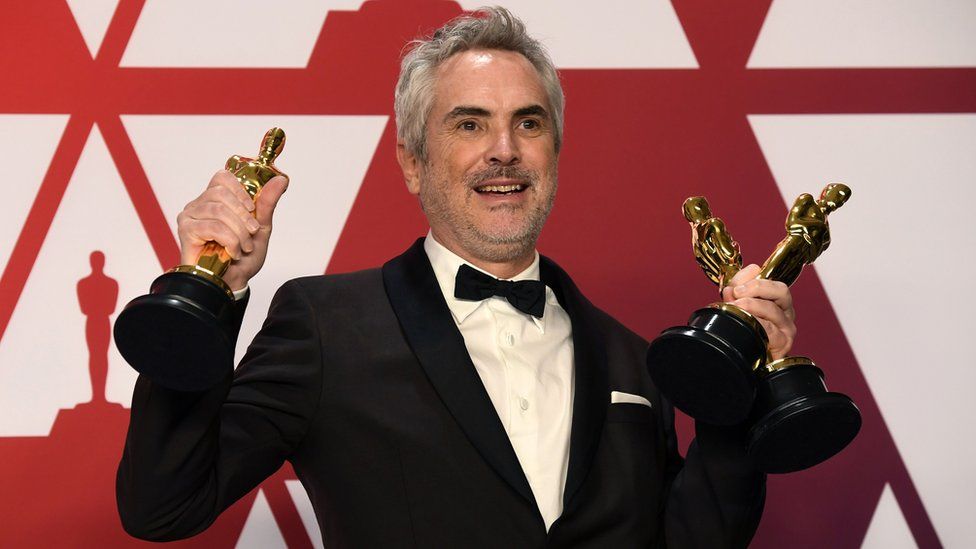 Alfonso Cuaron with Roma's three awards