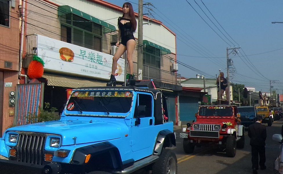 This picture taken on 3 January 2017 shows pole dancers performing on top of jeeps during the funeral procession of former Chiayi City county council speaker Tung Hsiang in Chiayi City, southern Taiwan