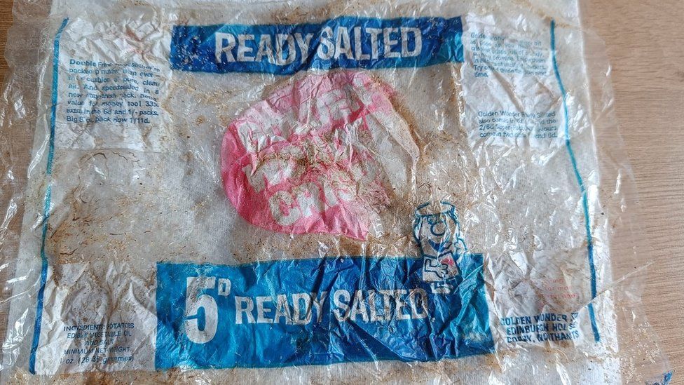Old crisp packet, faded with age, with 5D, ready salted and Golden Wonder brand visible