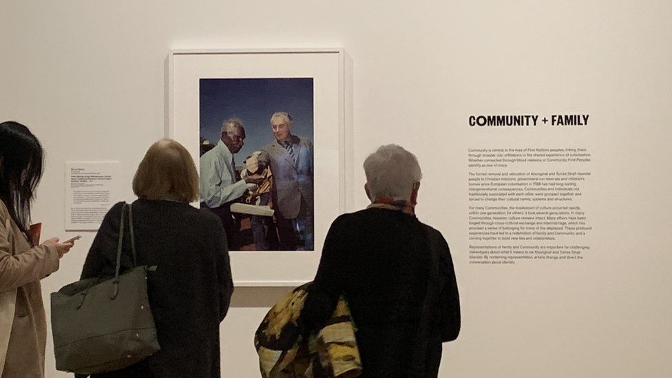 Museum visitors at Auckland Art Gallery look at a famous photograph of Australian Prime Minister Gough Whitlam pouring soil into the hand of traditional land owner Vincent Lingiari in 1975 in a historic meeting that symbolised the land rights struggle.