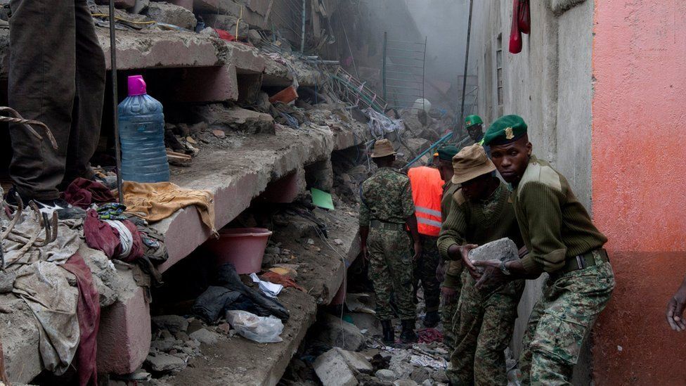 Kenyan National Youth Service personnel remove stones with hands at the site of a building collapse in Nairobi, Kenya, Saturday, April 30, 2016