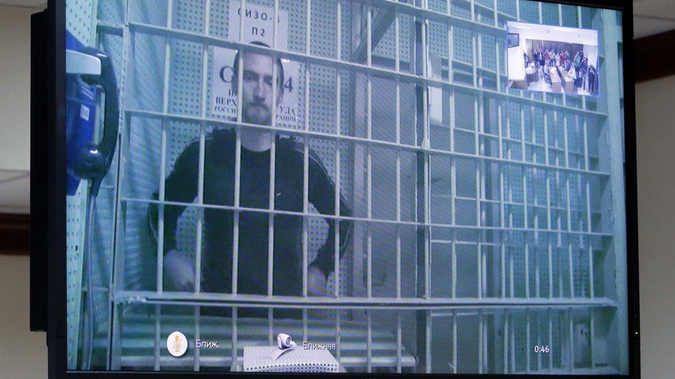Ustinov appeared in court via video link from prison