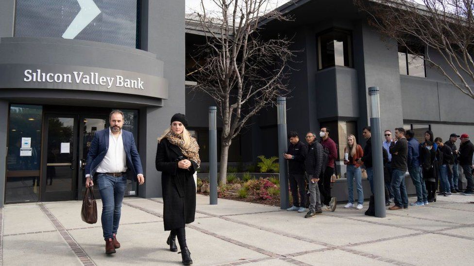 People queue up outside the headquarters of Silicon Valley Bank to withdraw their funds on March 13, 2023 in Santa Clara, California.
