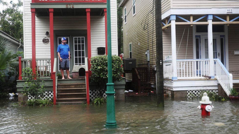 Джон Террецца смотрит на затопленную улицу перед своим домом, когда ураган Салли проходит 16 сентября 2020 года в Пенсаколе, Флорида