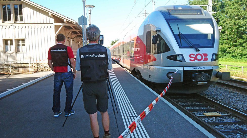 Police beside the train in Salez, eastern Switzerland (13 August)