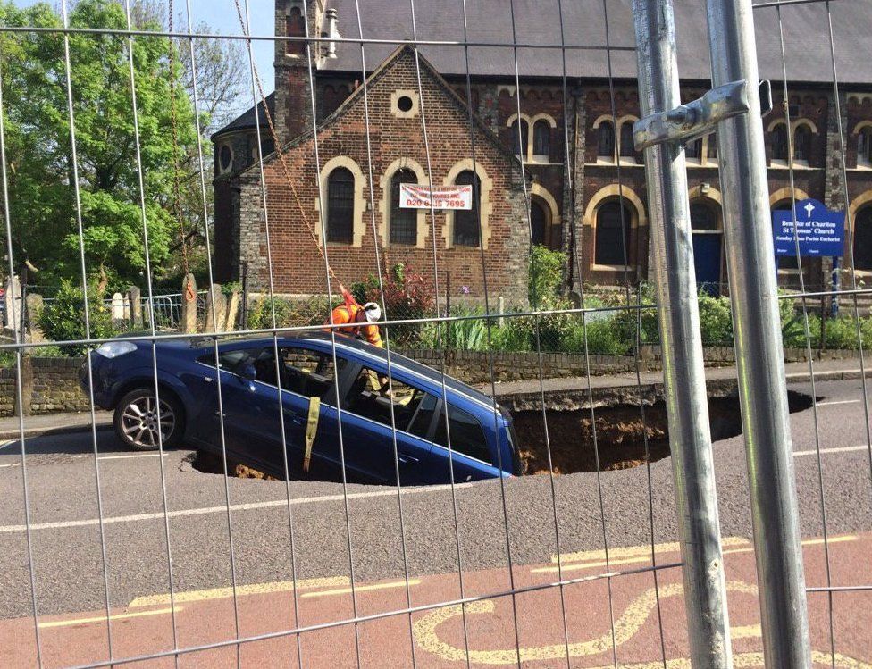 car being lifted out of the sink hole