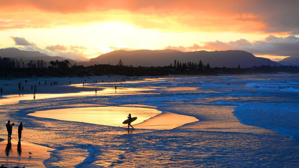 A surfer returns to shore in Byron Bay