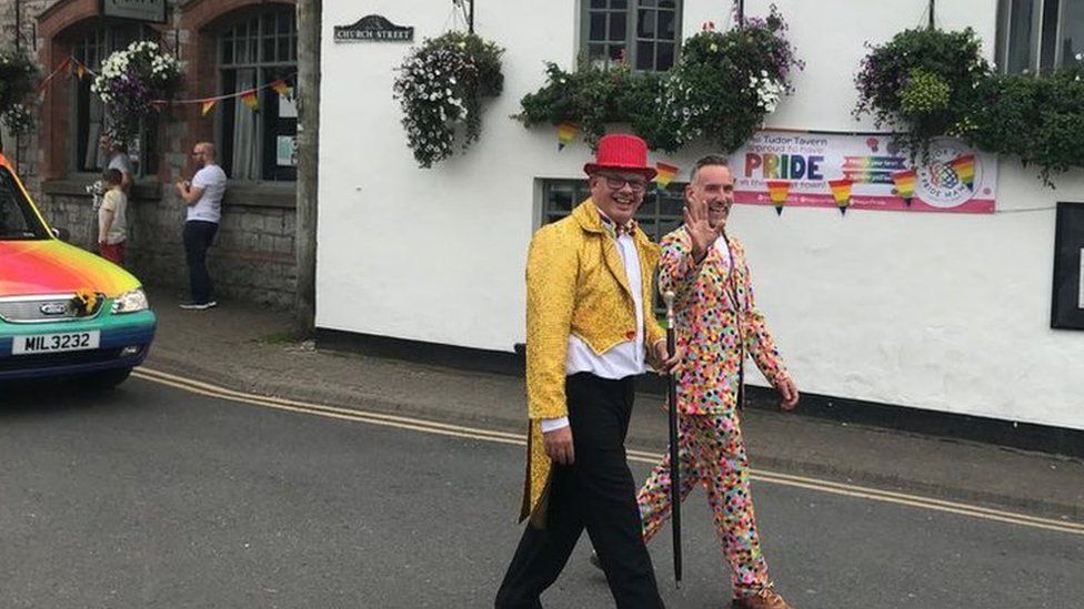 Two men walking outside a pub as part of Pride