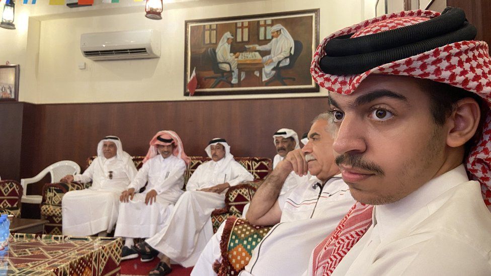 A group of Qatari men sit around watching the country's opening game of the 2022 World Cup against Ecuador