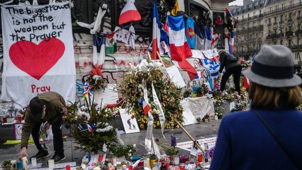 One month after the Paris attacks, people continue to gather in front of the memorial of candles and flowers for the victims of the 13 November Paris attacks, on Place de la Republique in Paris, France, 13 December 2015