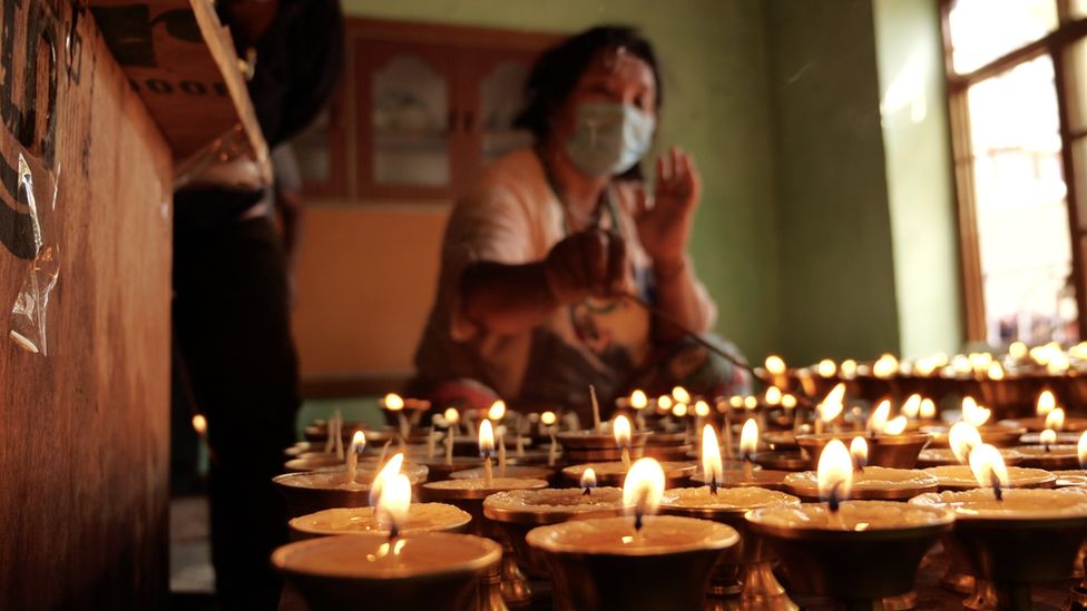 Nayima Tenzin's sister lighting oil lamps.