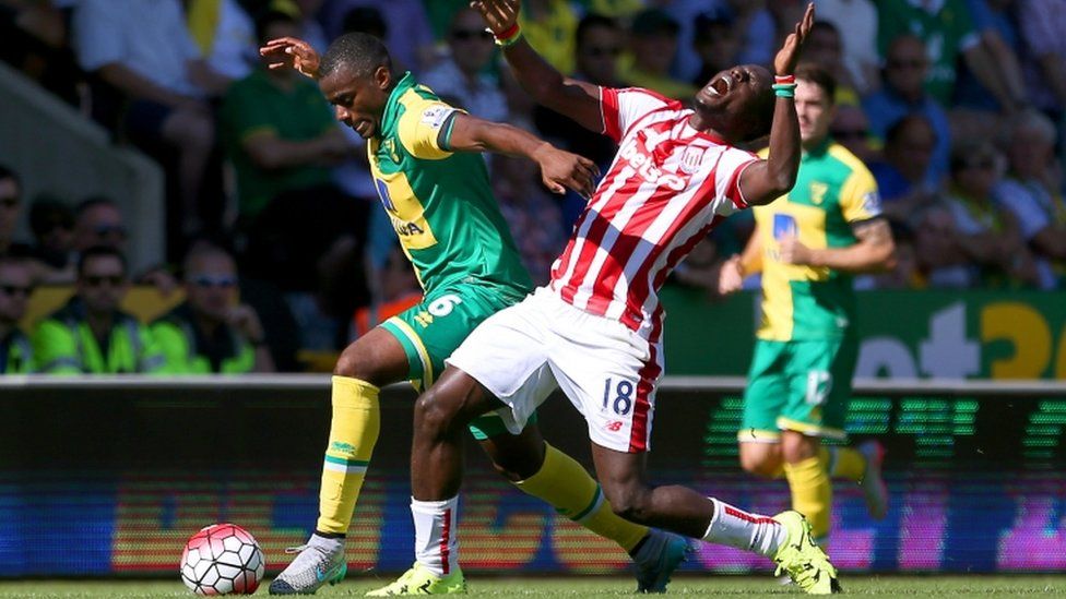 Norwich City"s Sebastien Bassong (left) and Stoke City's Mame Biram Diouf battle for the ball during the Barclays Premier League match at Carrow Road, Norwich