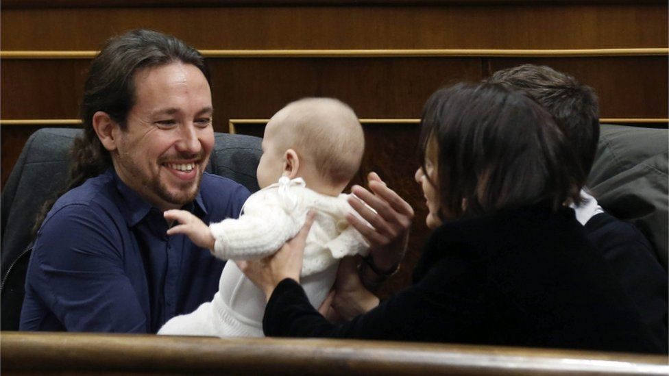 Spanish MP of the Podemos party Carolina Bescansa (right) hands over her baby to the party's leader, Pablo Iglesias