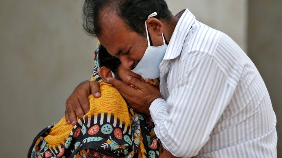 Женщину утешает родственник возле больницы в Ахмедабаде, Индия, после того, как ее муж умер от коронавирусной болезни