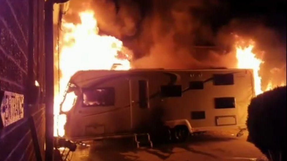 Flames engulfing a caravan outside the property