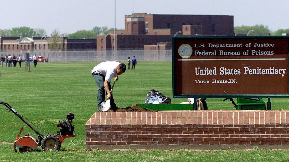 A worker cleans a sign at the death row in Terre Haute, Indiana
