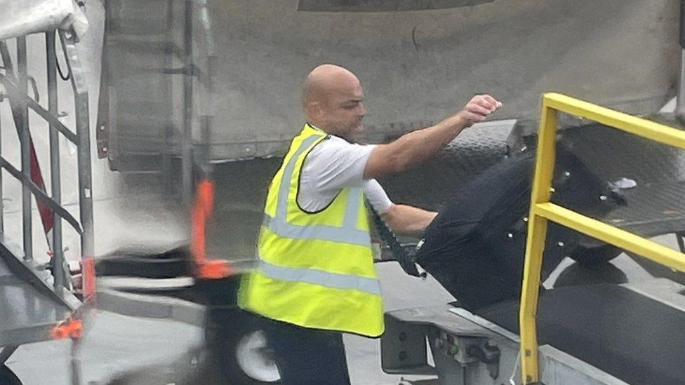 Co-pilot loading luggage on plane