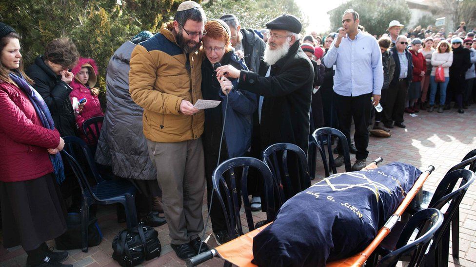 The husband and son of Dafna Meir speak during her funeral at the Jewish settlement of Otniel (18 January 2016)