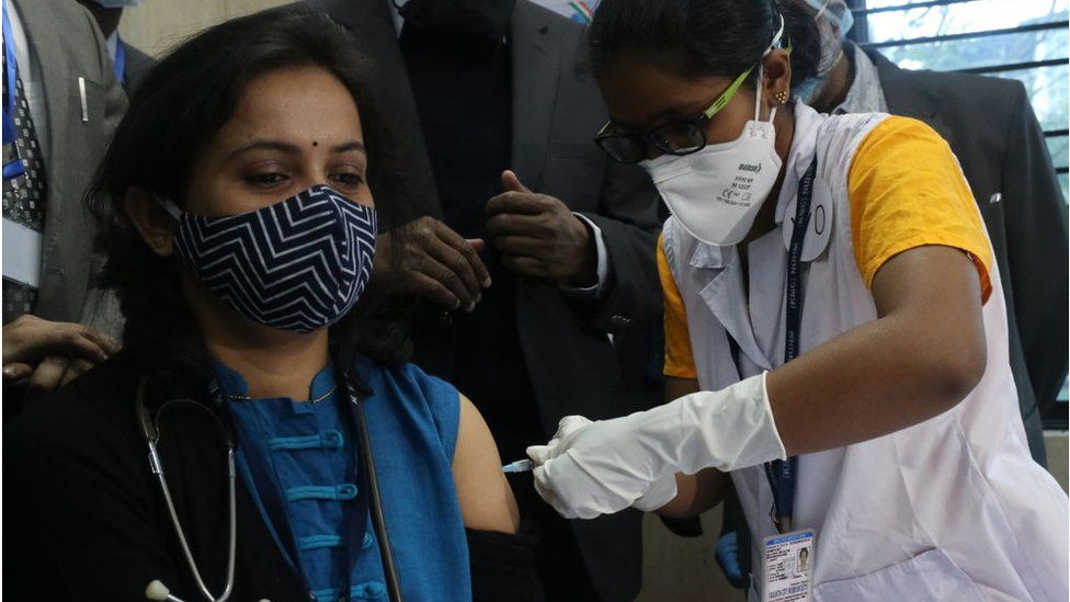 A doctor receives the vaccine jab