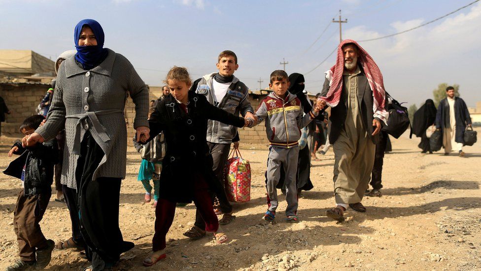 A family fleeing fighting between the Islamic State and Iraqi army in Intisar district of eastern Mosul, make their way to safer territory, Iraq November 8, 2016