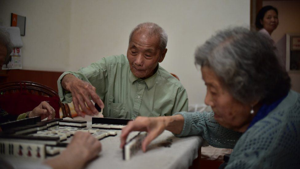 A group of elderly people plays mahjong at a home in Shanghai
