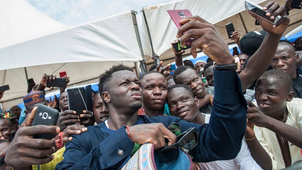 Ghanaian footballer, Sulley Muntari, takes a selfie with fans at Independence Square the celebration of the Eid al-Fitr, on June 15, 2018 at the Independence Square in Accra